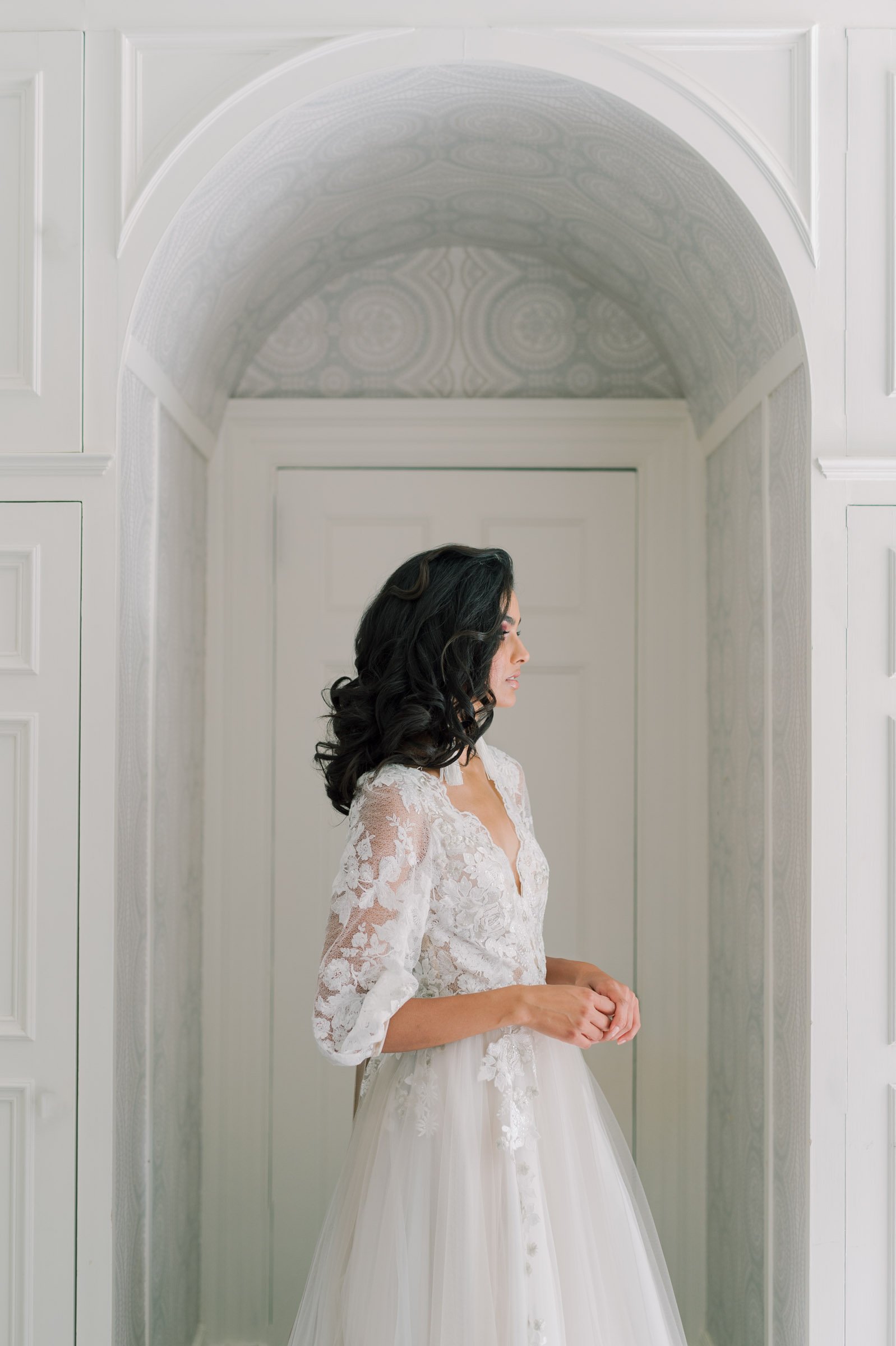 brunette side portrait with same blue orgnza and lace dress on. een standing in a white arched doorway at Graydon hall Manor.