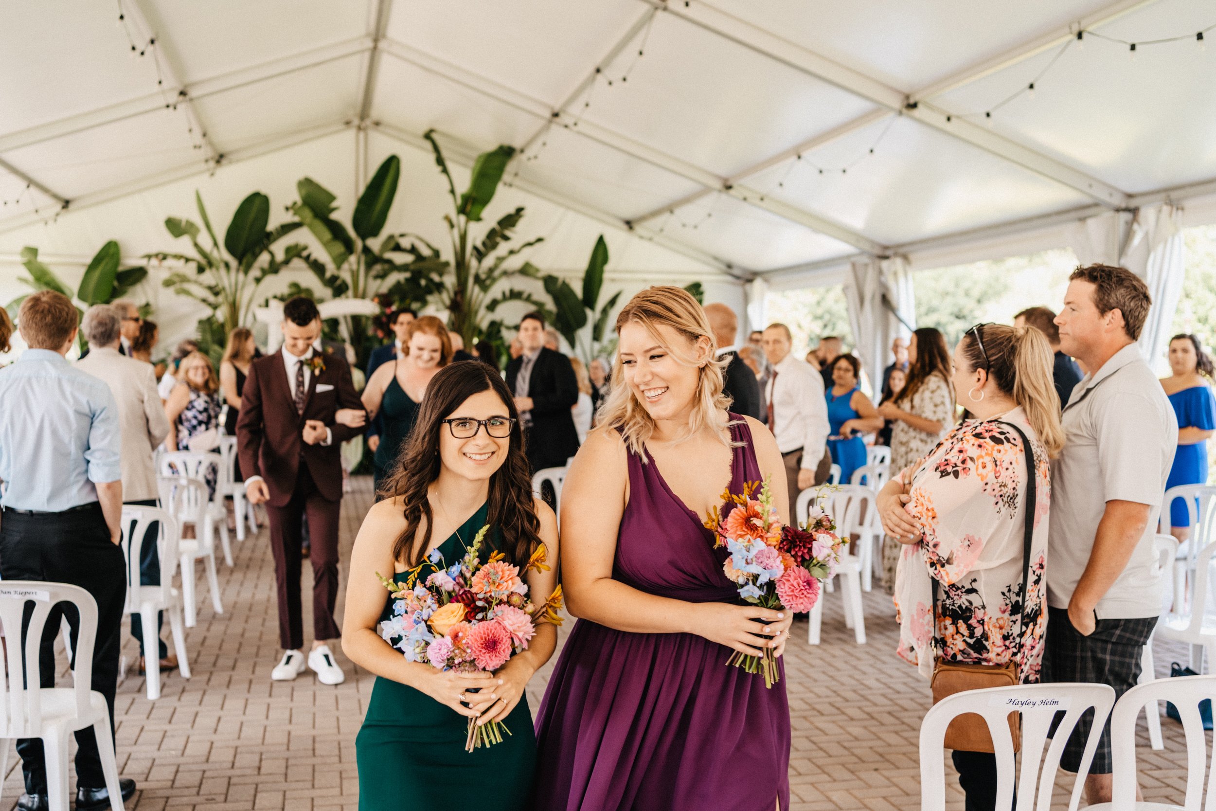 the groom's sister and her partner walk down the aisle