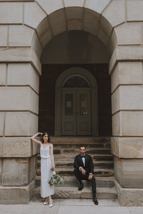 Bride and Groom stand outside an entrance way.