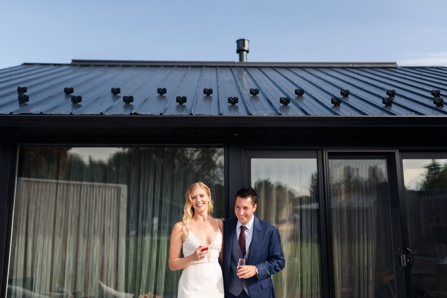 Lauren and Cody, the bride and groom, posing outside their cottage at Wander the Resort in Prince Edward County.