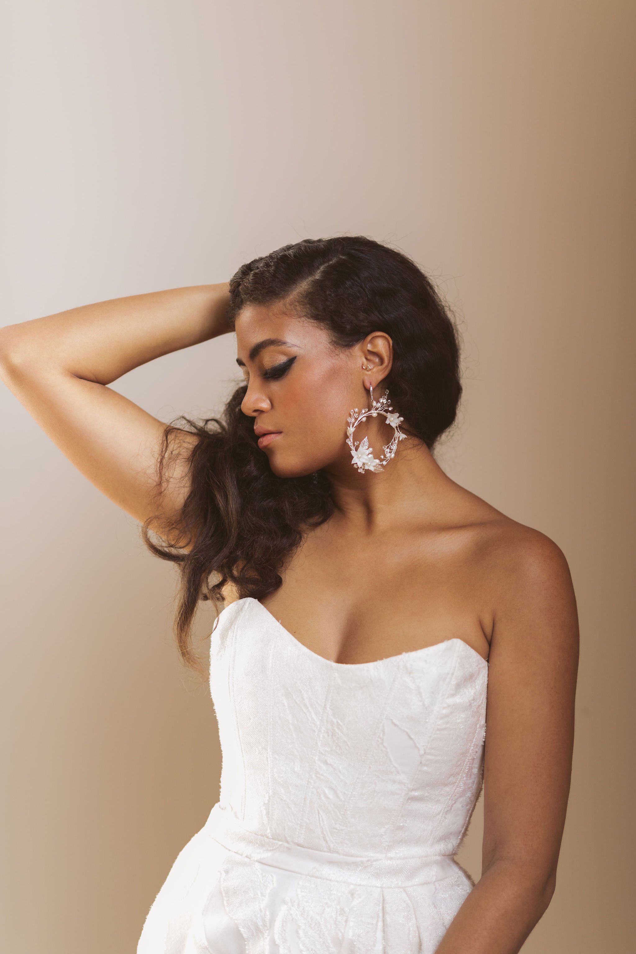 bride looking down, one arm raised behind her head.