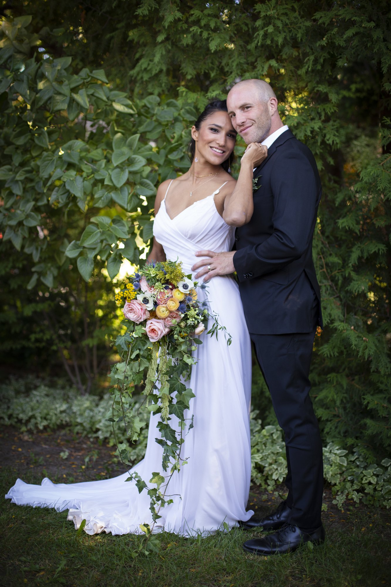 bride and groom pose in summertime